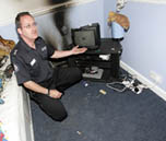 Station Officer Pat O' Hanlon demonstrating the burnt out bedroom